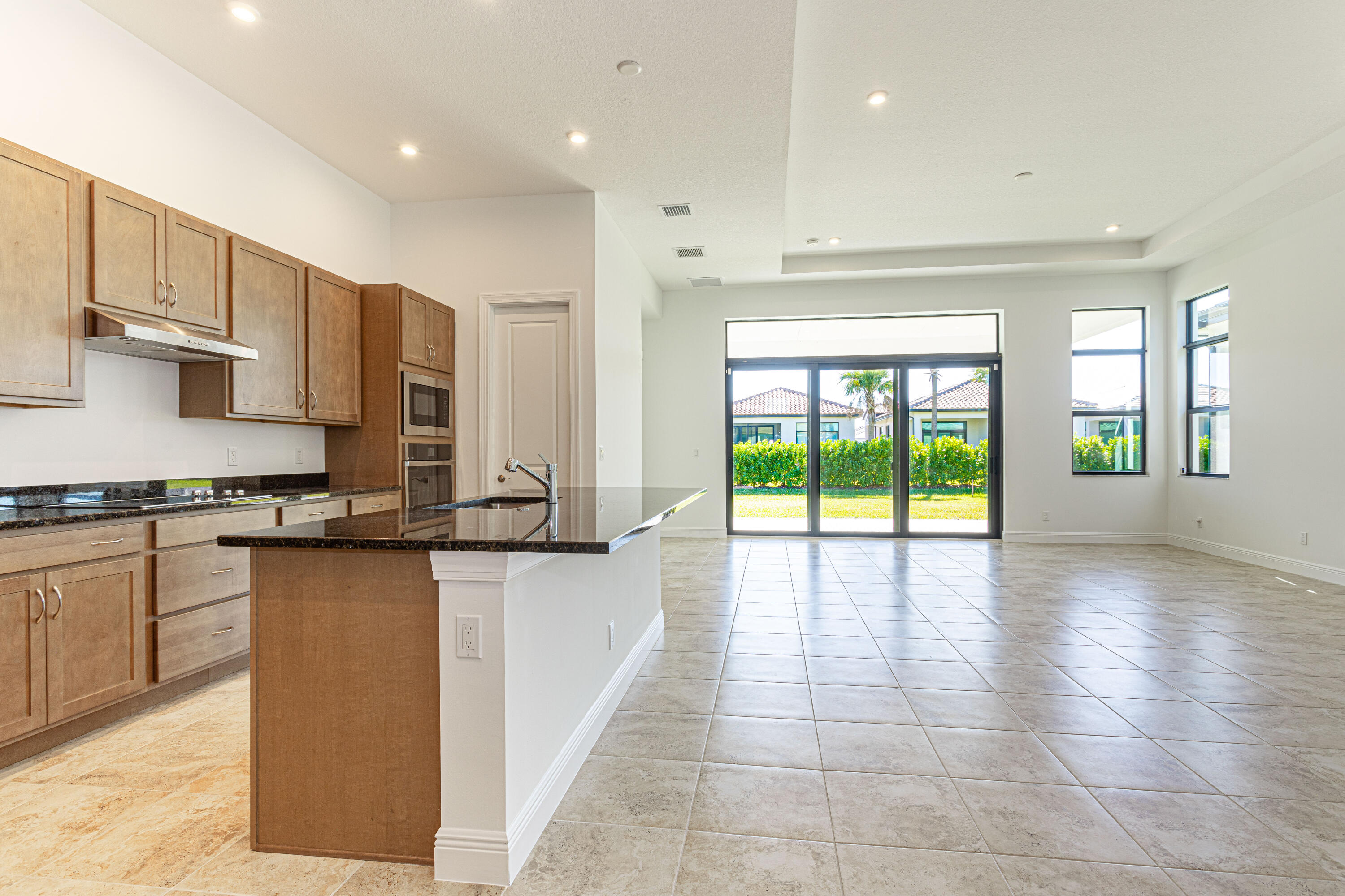 9155 Southwest Esule Way Port St. Lucie, FL 34987 - Photo 10 of 49 a large kitchen with stainless steel appliances granite countertop a large counter top and a stove top oven