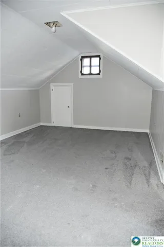 an empty room with closet and a hallway