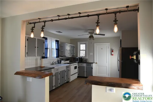 a kitchen with stainless steel appliances granite countertop a sink and a refrigerator