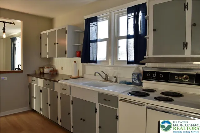 a kitchen with a sink stove top oven and cabinets