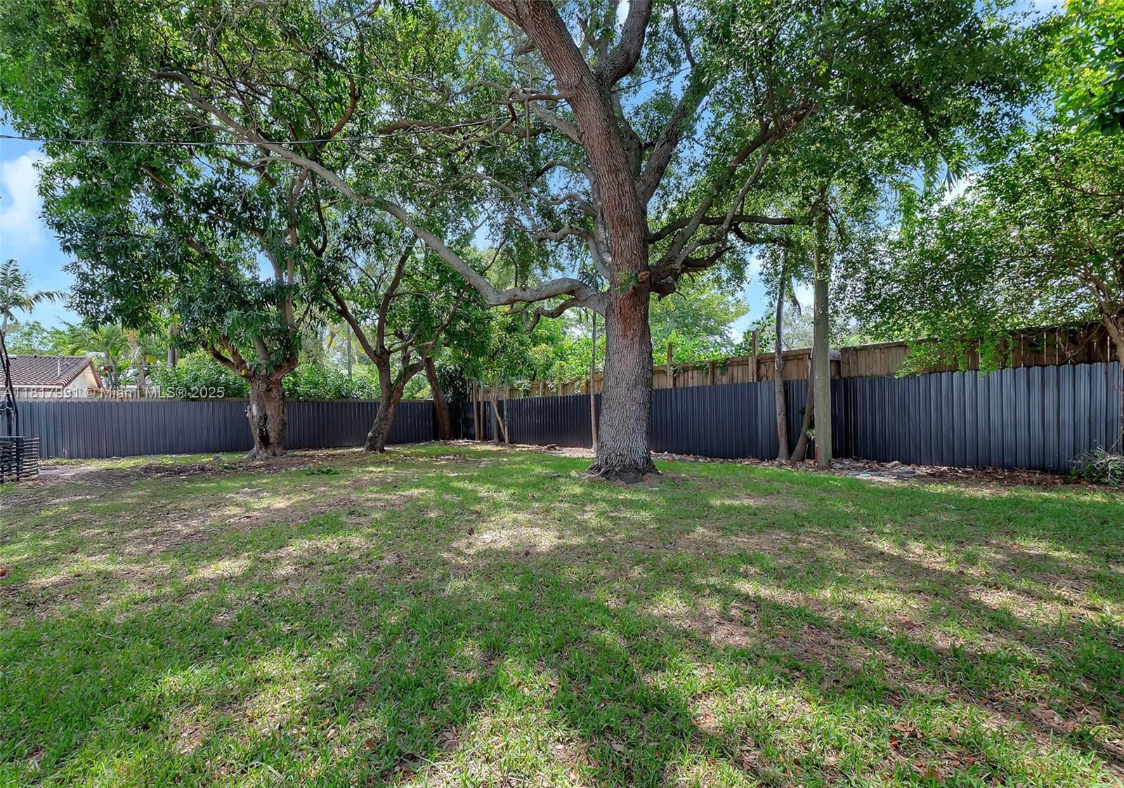 1852 Southwest 22nd Terrace, Unit 1 Miami, FL 33145 - Photo 24 of 24 a backyard with large trees and wooden fence
