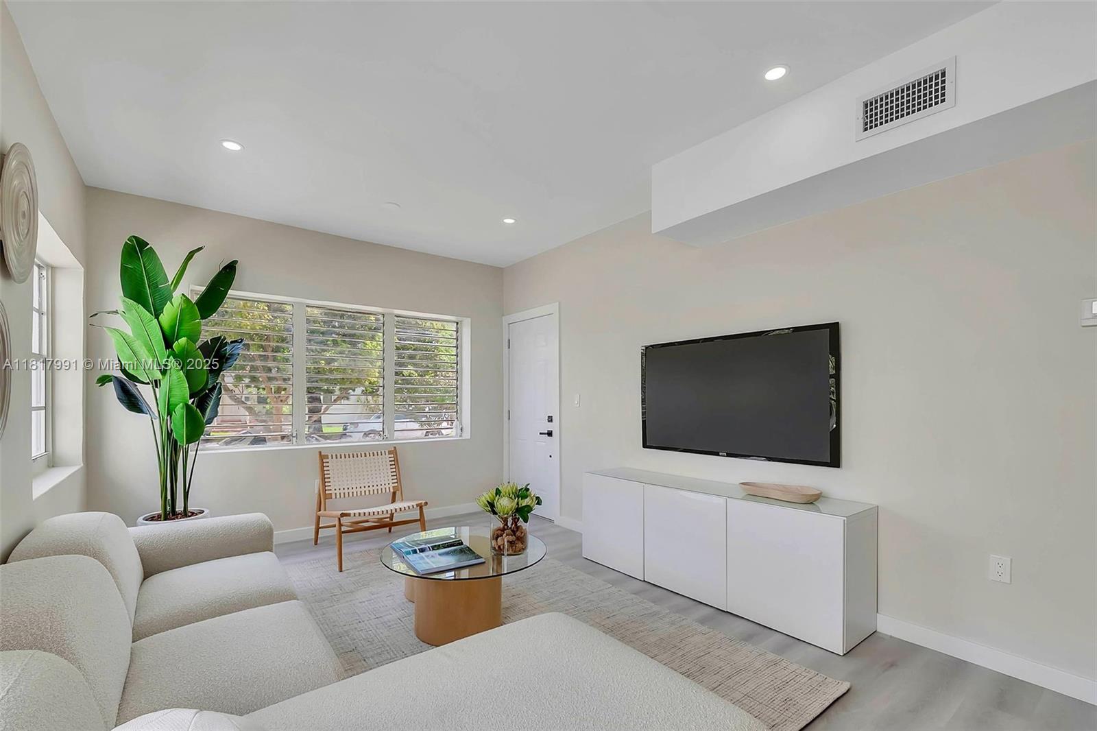 1852 Southwest 22nd Terrace, Unit 1 Miami, FL 33145 - Photo 3 of 24 a living room with furniture a flat screen tv and a potted plant