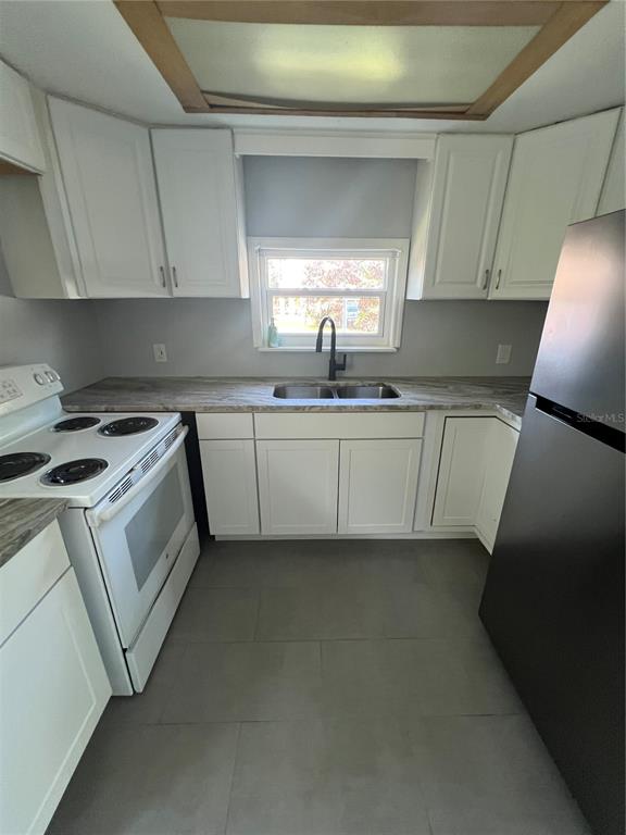 7222 Tropical Drive Weeki Wachee, FL 34607 - Photo 22 of 23 a kitchen with a sink a stove and cabinets