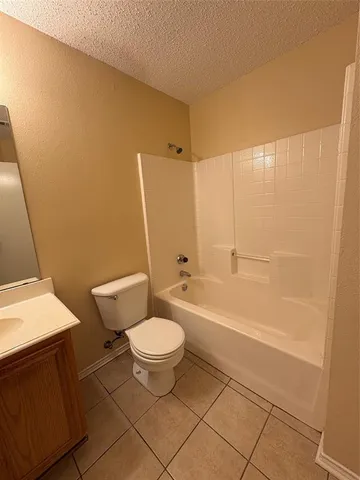 a bathroom with a granite countertop sink toilet a mirror and bathtub