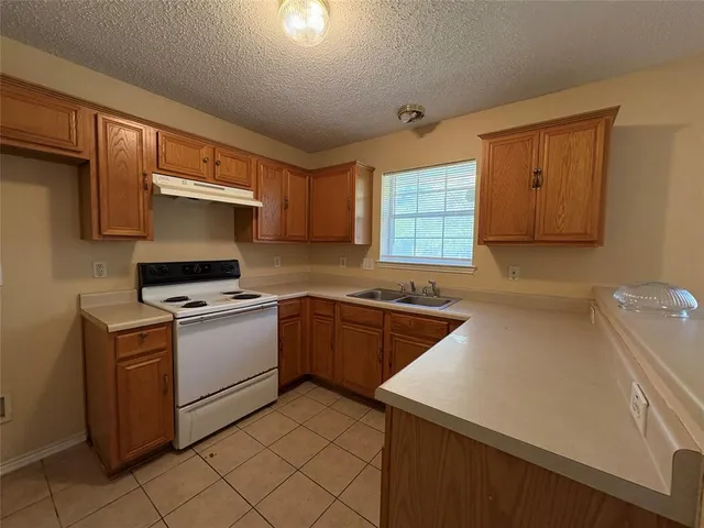 a kitchen that has a sink and a stove in it