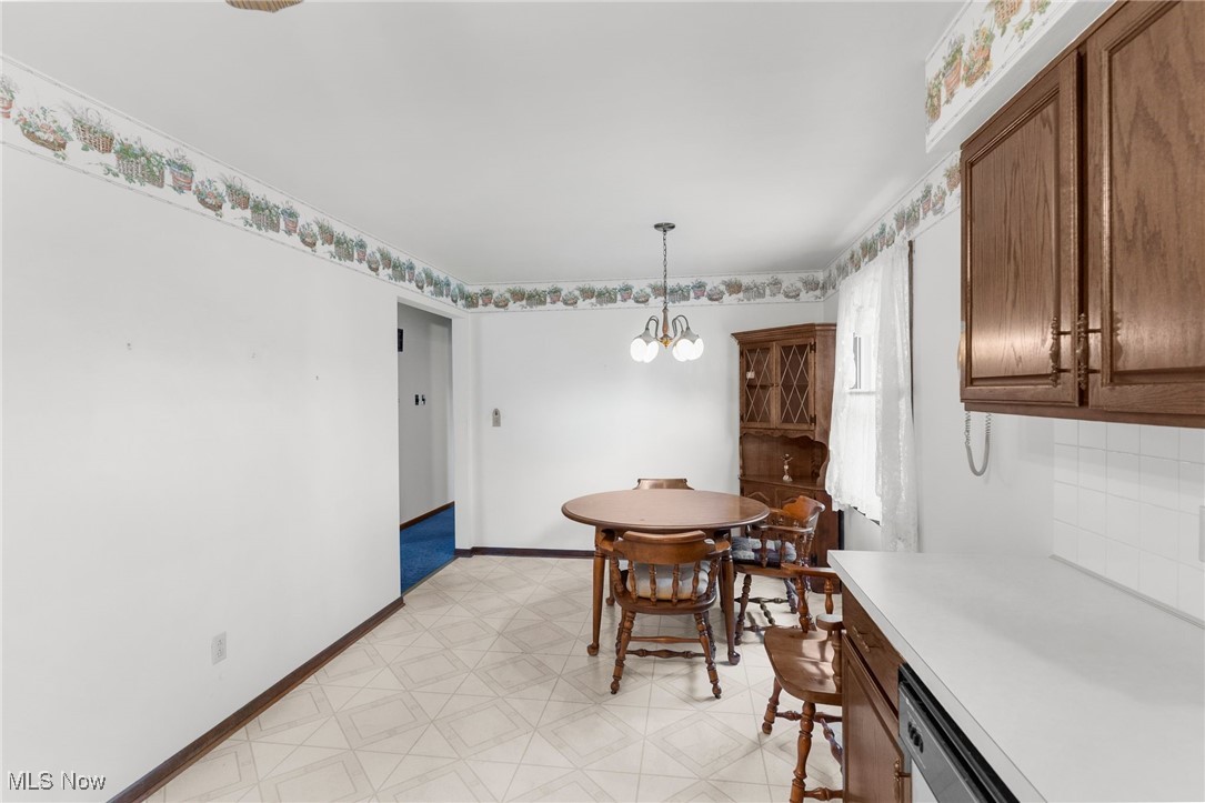 1295 Shields Road Youngstown, OH 44511 - Photo 10 of 27 Dining room featuring light floors, a chandelier, and baseboards