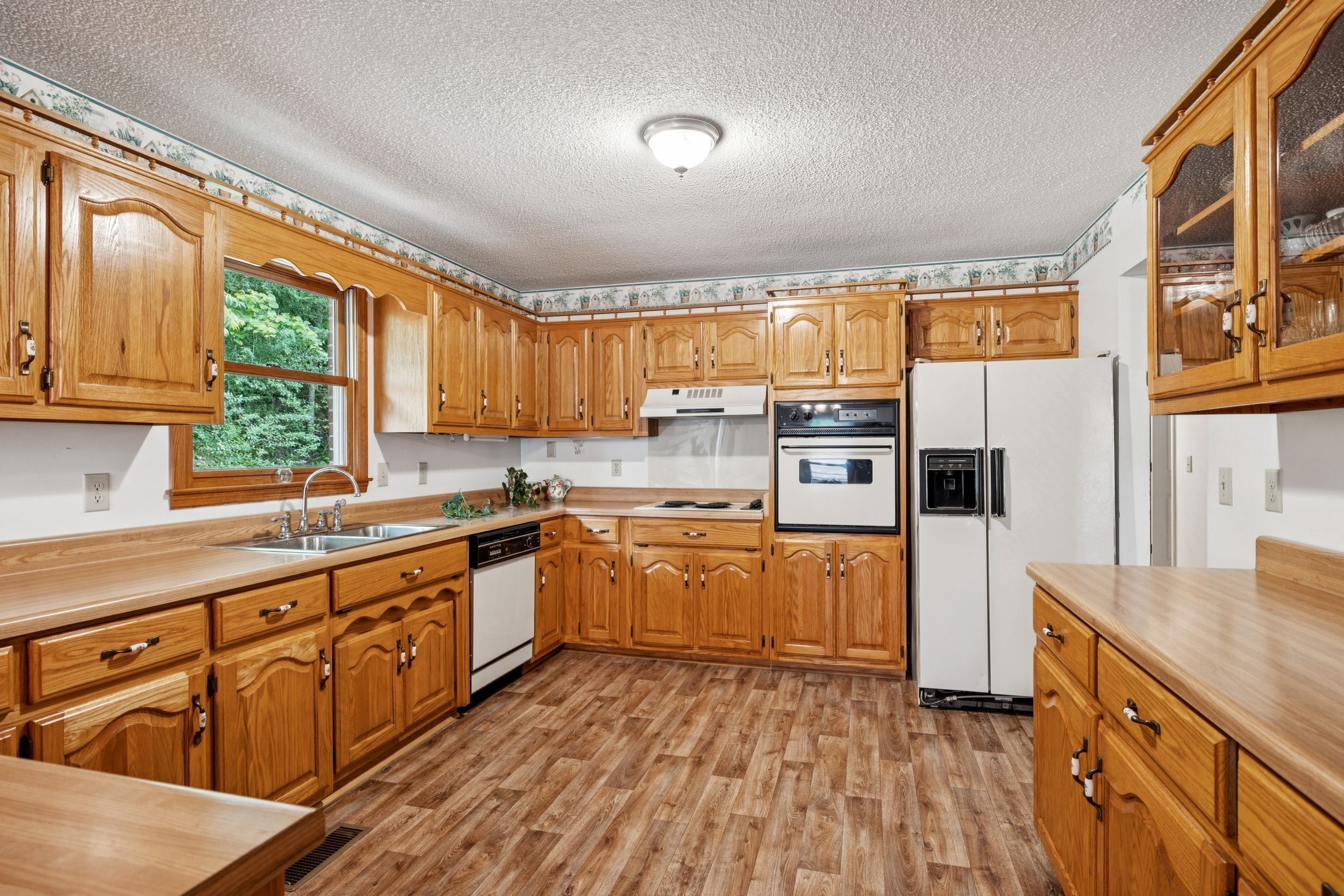 8663 Dog Branch Road Mount Pleasant, TN 38474 - Photo 14 of 42 a kitchen with stainless steel appliances granite countertop a refrigerator a sink dishwasher a stove and white countertops with wooden floor