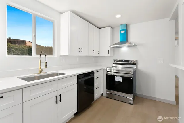 a kitchen with cabinets appliances and a sink