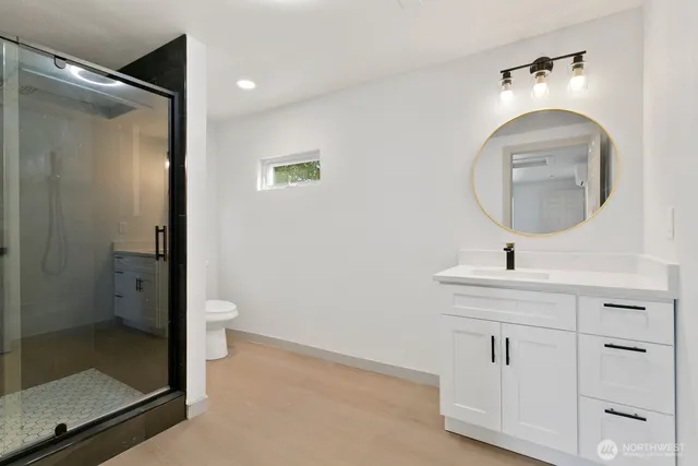 a bathroom with a toilet a sink and mirror