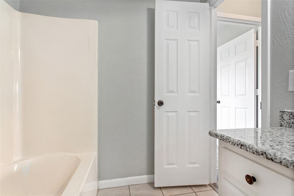 712 Billups Street Van Alstyne, TX 75495 - Photo 31 of 38 a bathroom with a granite countertop sink and a mirror