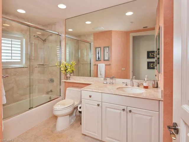 a bathroom with a shower sink vanity mirror and toilet