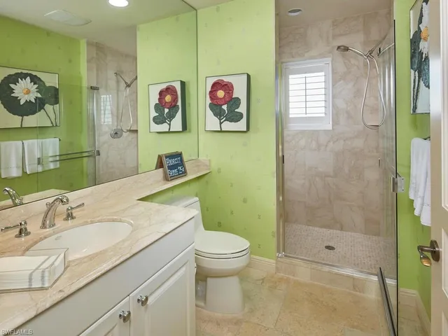 a bathroom with a granite countertop sink a toilet and a shower