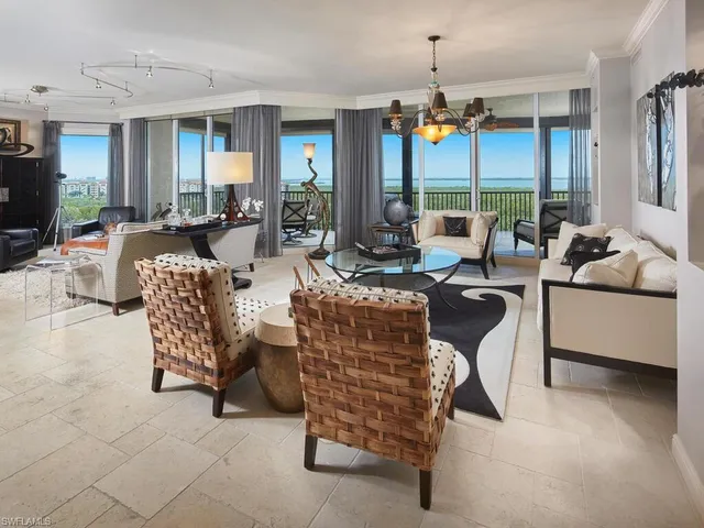 a living room with patio furniture and a chandelier