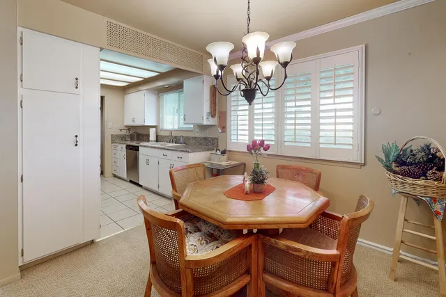 a dining room filled chandelier and wooden floor