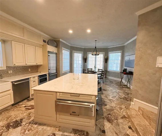 a kitchen with kitchen island a stove a sink and a refrigerator