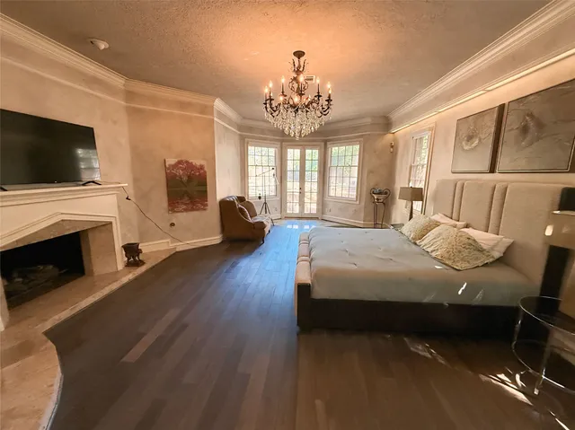 a spacious bedroom with a bed and a flat screen tv