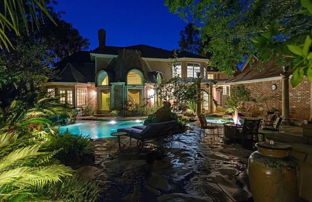 a view of a house with backyard and sitting area