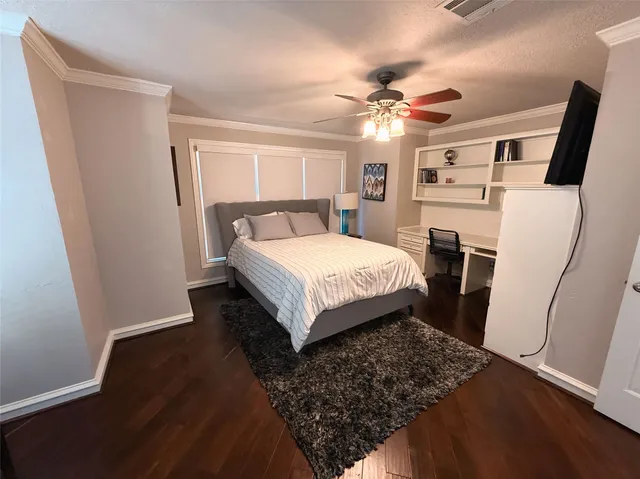 a bed room with a bed and a ceiling fan