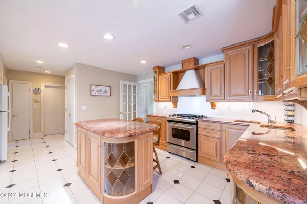 a kitchen with stainless steel appliances granite countertop a stove top oven a sink dishwasher and a refrigerator