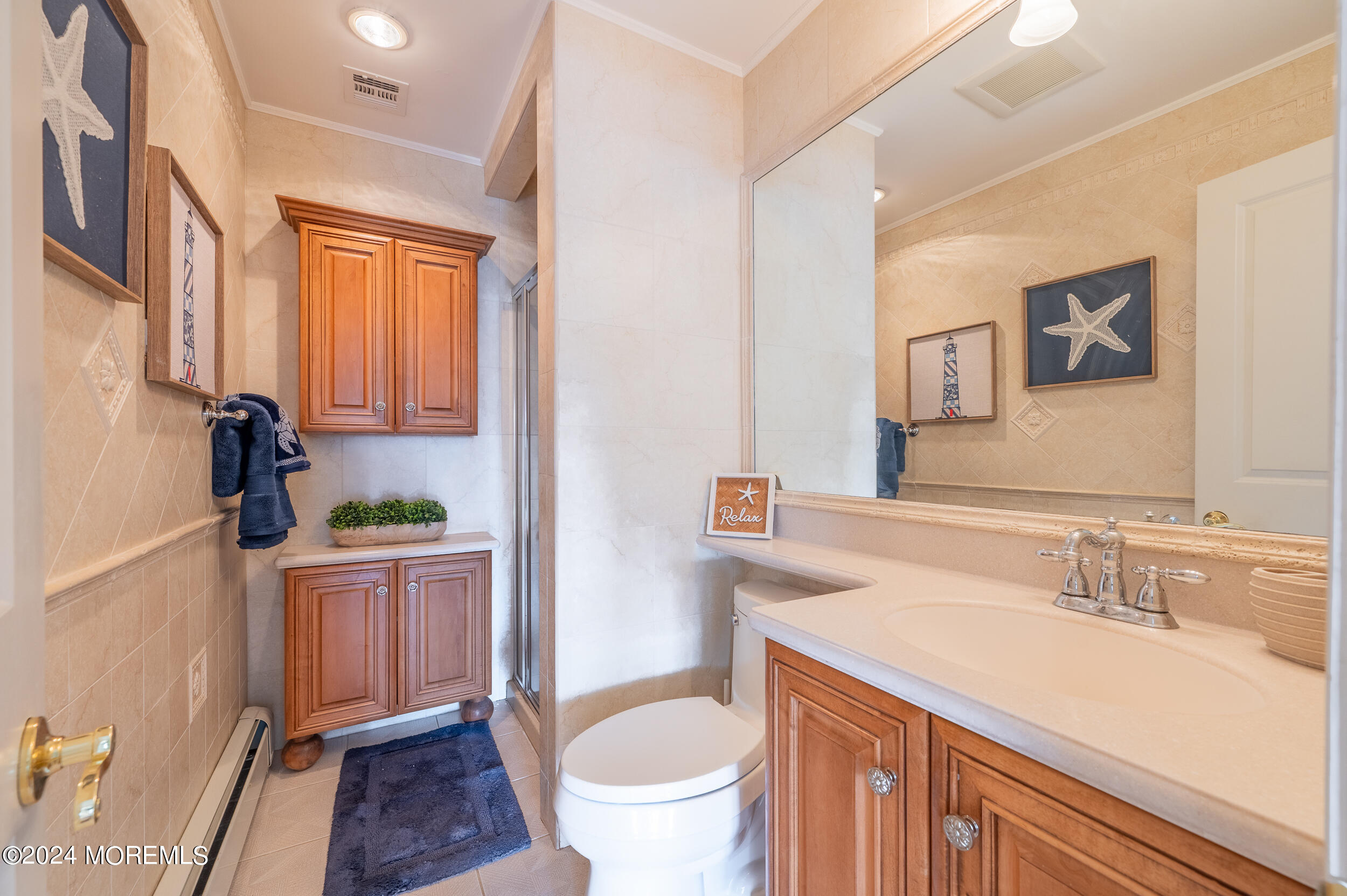 409 6th Avenue Seaside Heights, NJ 08751 - Photo 22 of 39 a bathroom with a sink a toilet and a mirror