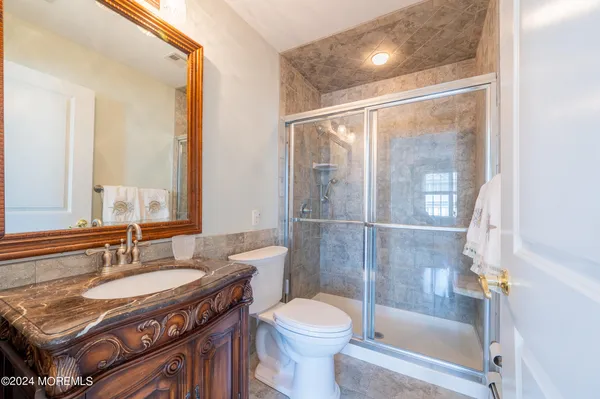 a bathroom with a granite countertop sink toilet and shower