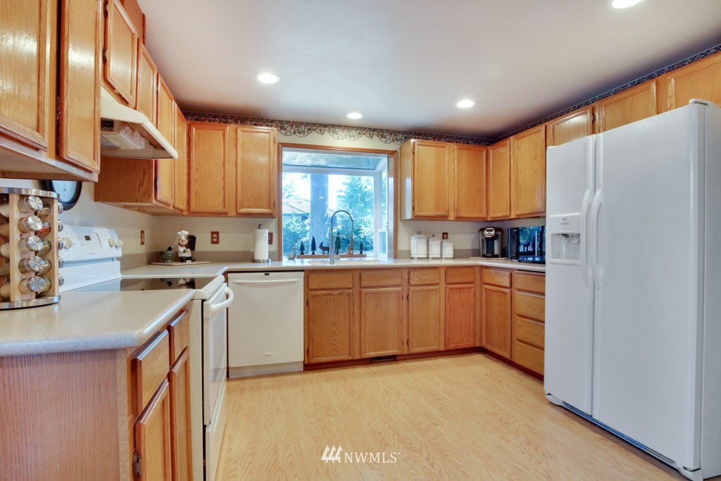 5624 Hazel Loop Southeast Auburn, WA 98092 - Photo 6 of 16 a kitchen with a refrigerator a sink a stove a microwave a center island and cabinets