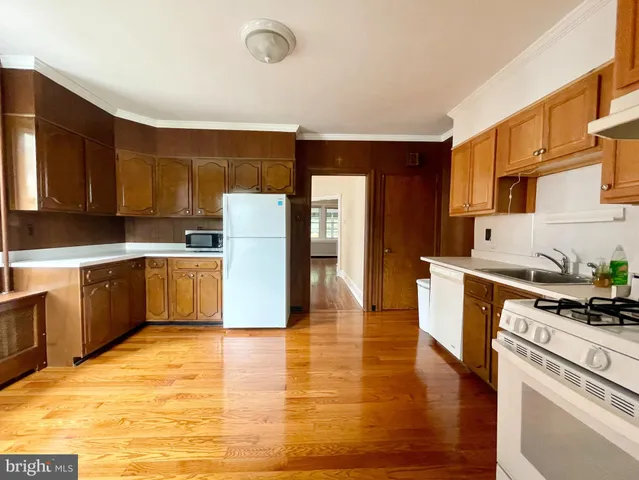 a kitchen with granite countertop a refrigerator stove top oven and cabinets
