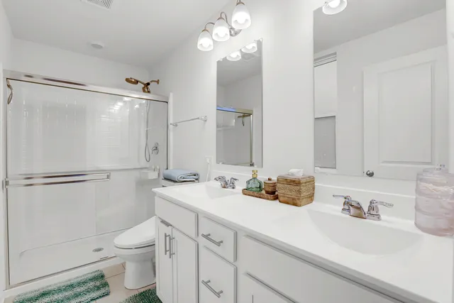 a bathroom with a double vanity sink mirror and toilet