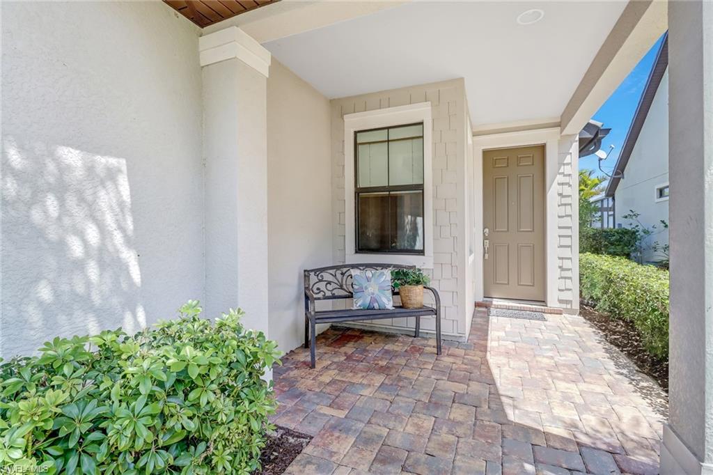 20321 Corkscrew Shores Boulevard Estero, FL 33928 - Photo 23 of 38 a porch with a bench and a garden