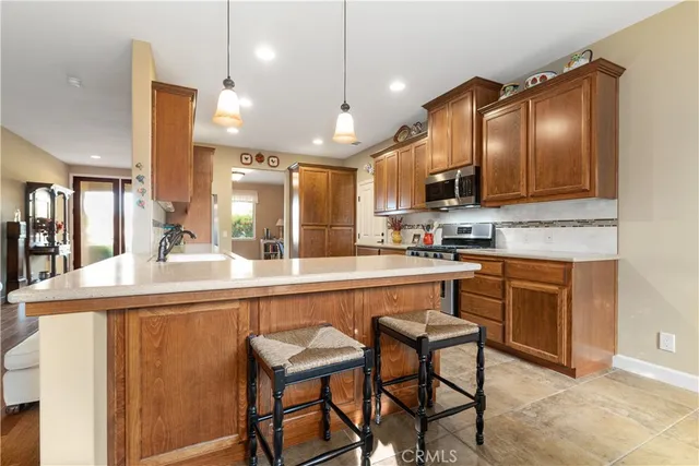 a kitchen with kitchen island granite countertop a sink and a refrigerator