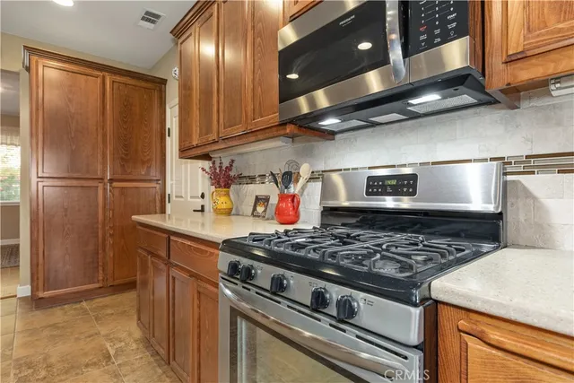 a large kitchen with stainless steel appliances granite countertop a sink counter space cabinets and a large window