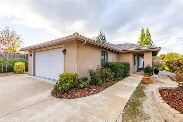 a front view of a house with a yard and potted plants