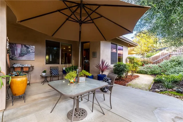 a view of a patio with table and chairs under an umbrella