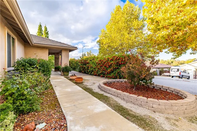 a view of a house with a yard and potted plants