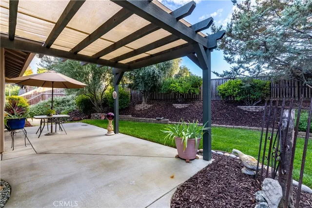 a view of a patio with a table and chairs under an umbrella