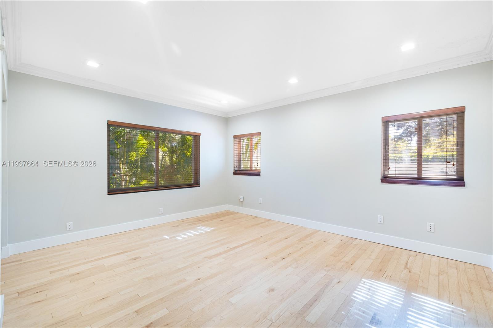 1375 North Biscayne Point Road Miami Beach, FL 33141 - Photo 20 of 40 a view of an empty room with wooden floor and a window