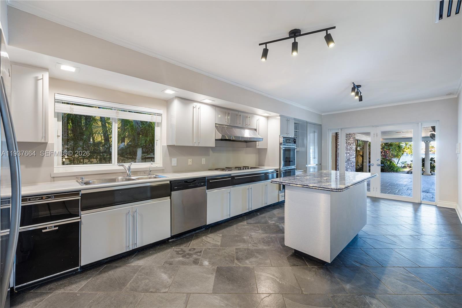 1375 North Biscayne Point Road Miami Beach, FL 33141 - Photo 30 of 40 a large kitchen with kitchen island a sink counter space appliances and a window