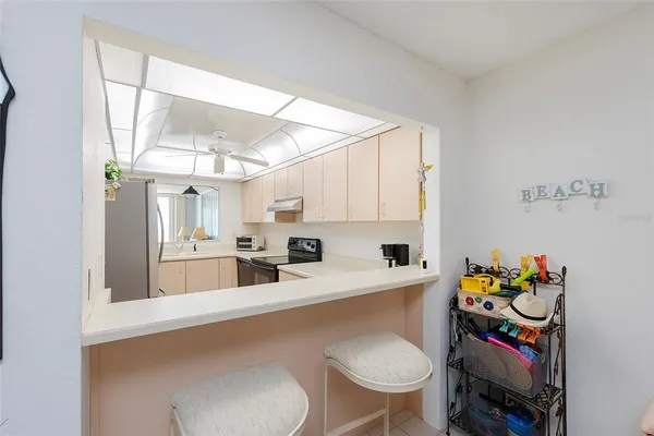 a kitchen with a white cabinets and chairs