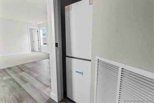 a view of a hallway with wooden floor and entryway