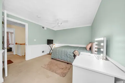 a bedroom with a white bed and white cabinets