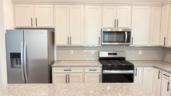a kitchen with cabinets stainless steel appliances and a window