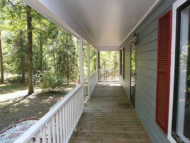7104 Blalock Road Bahama, NC 27503 - Photo 2 of 8 a view of a porch with wooden floor and stairs