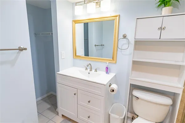 a bathroom with a toilet sink vanity and mirror