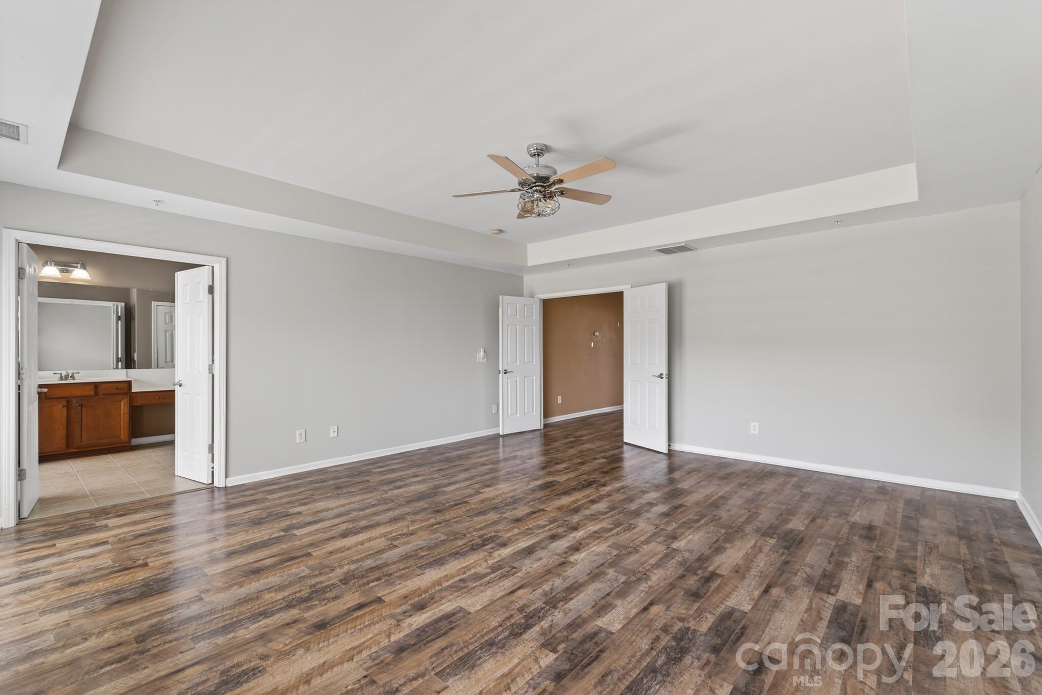 114 Inlet Point Drive Tega Cay, SC 29708 - Photo 15 of 40 an empty room with wooden floor and a ceiling fan