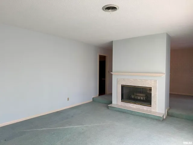 a view of empty room with a fireplace