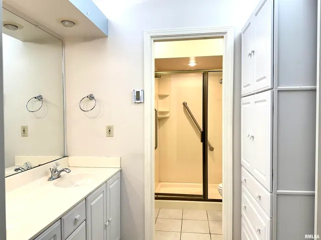 a bathroom with a granite countertop sink a shower and a mirror