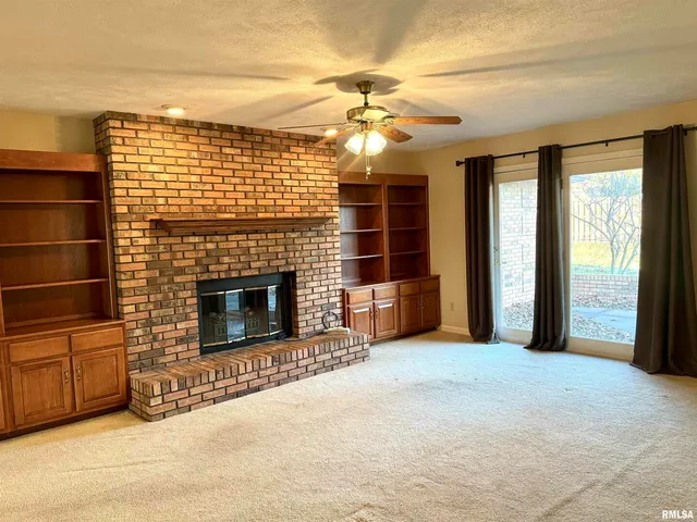 a view of a livingroom with a fireplace and window