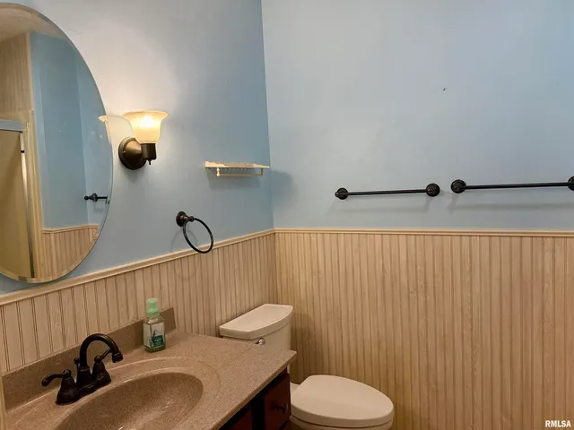 a bathroom with a sink a toilet and mirror
