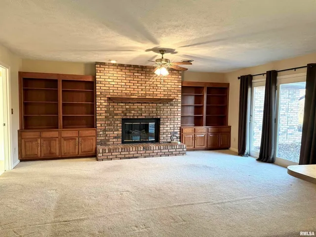 an empty room with a fireplace and cabinet