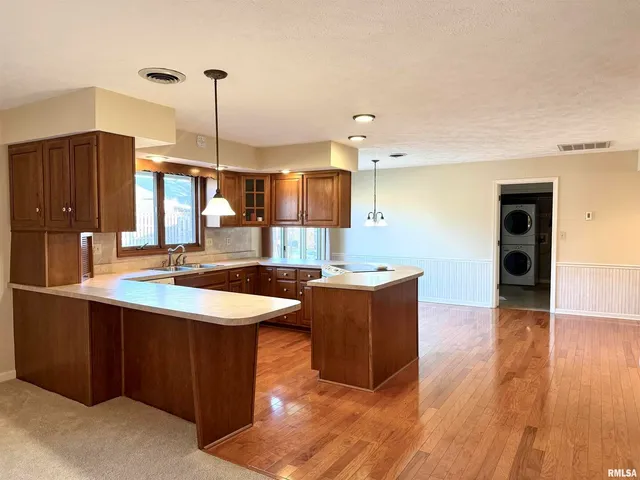 a kitchen with stainless steel appliances granite countertop a sink a counter space and wooden floor